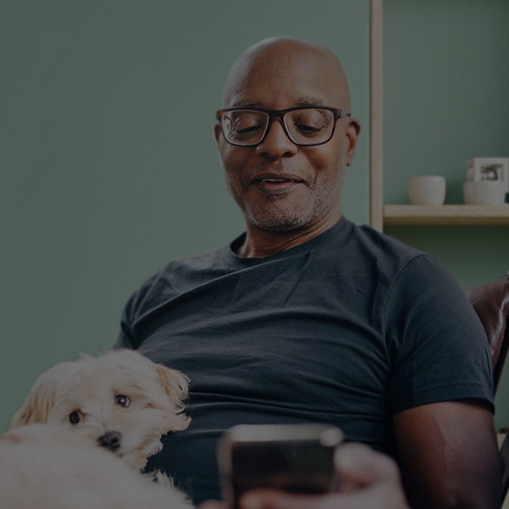  Ein alter Mann sitzt mit einem Hund auf seinem Schoß